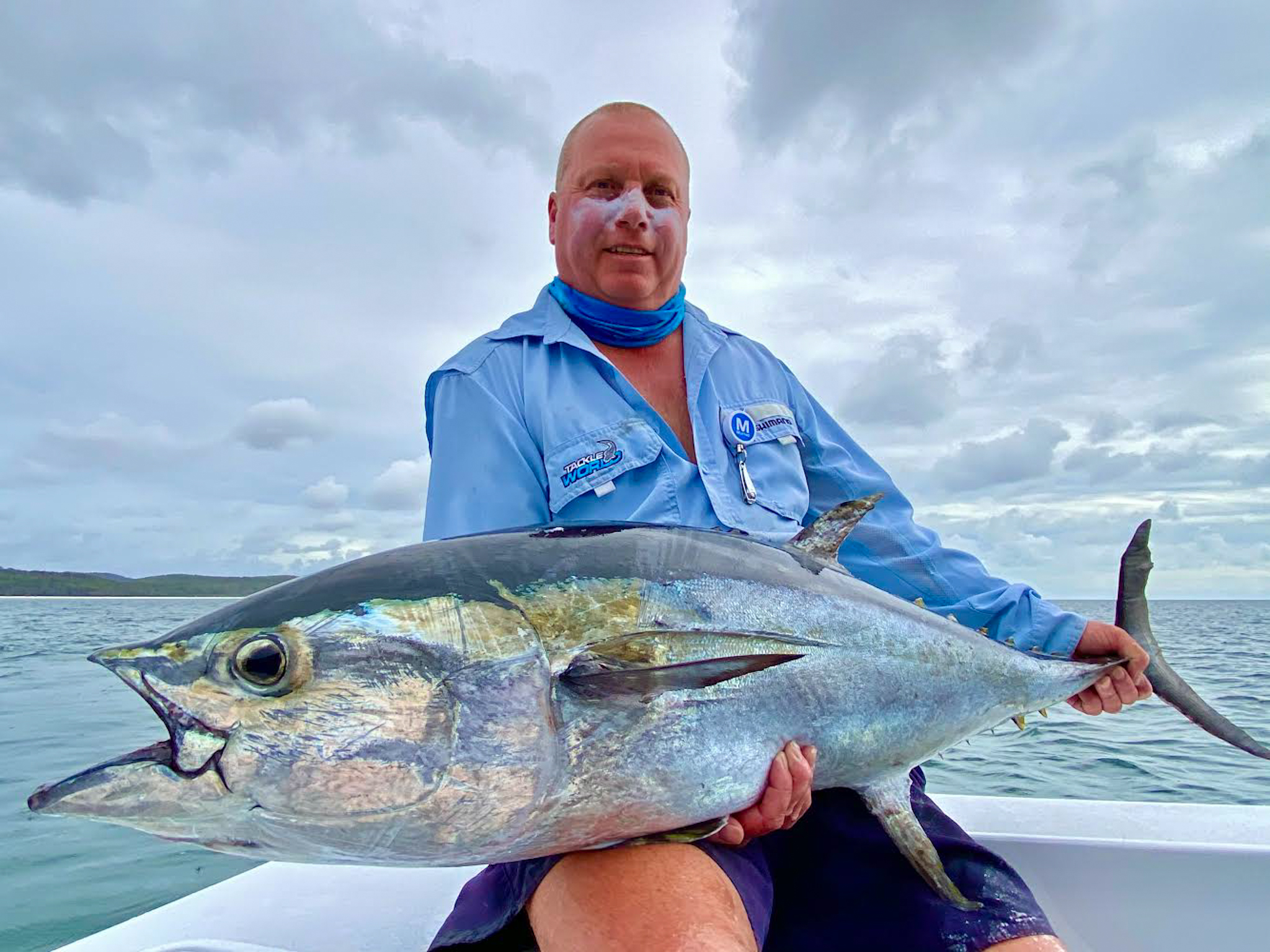 man holding a large red fish on a fishing charter in hervey bay, queensland, australia